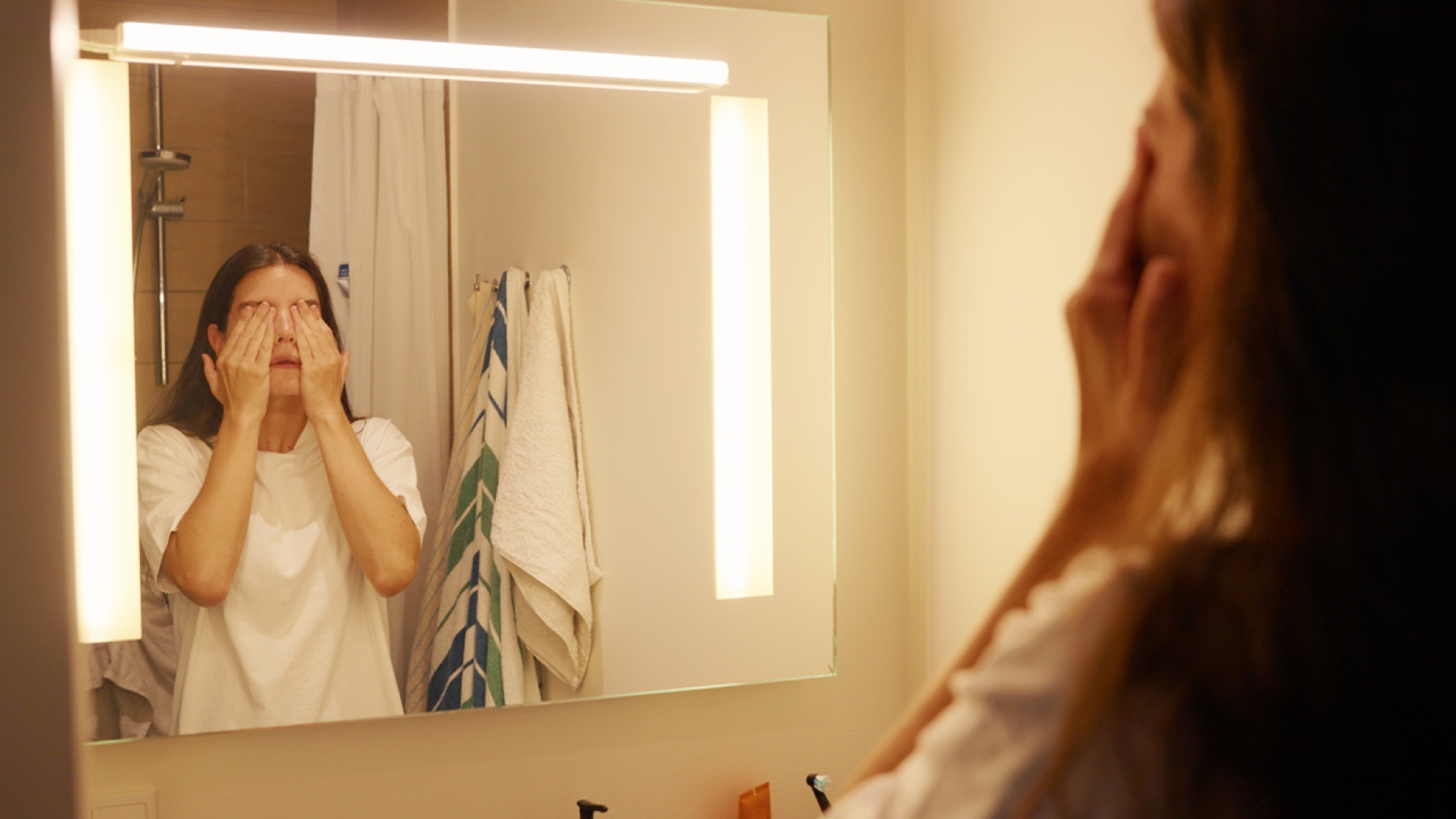 Dia reflected in a bathroom mirror during a private moment
