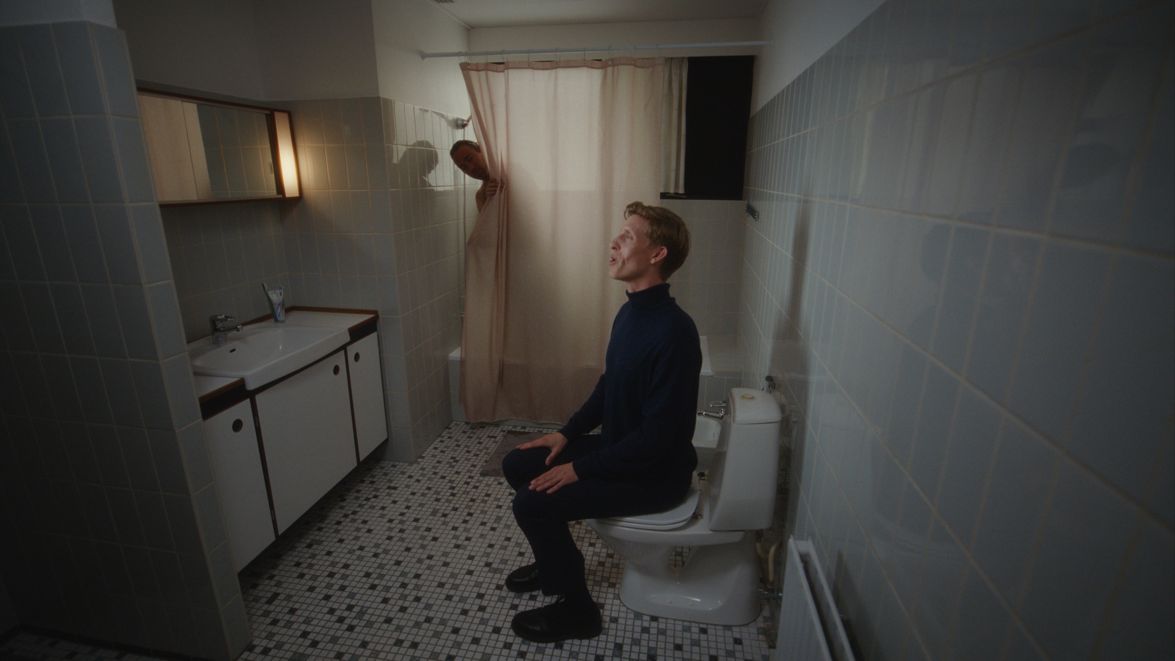 Dinero Pro assistant sitting in a bathroom while another character looks out from the shower