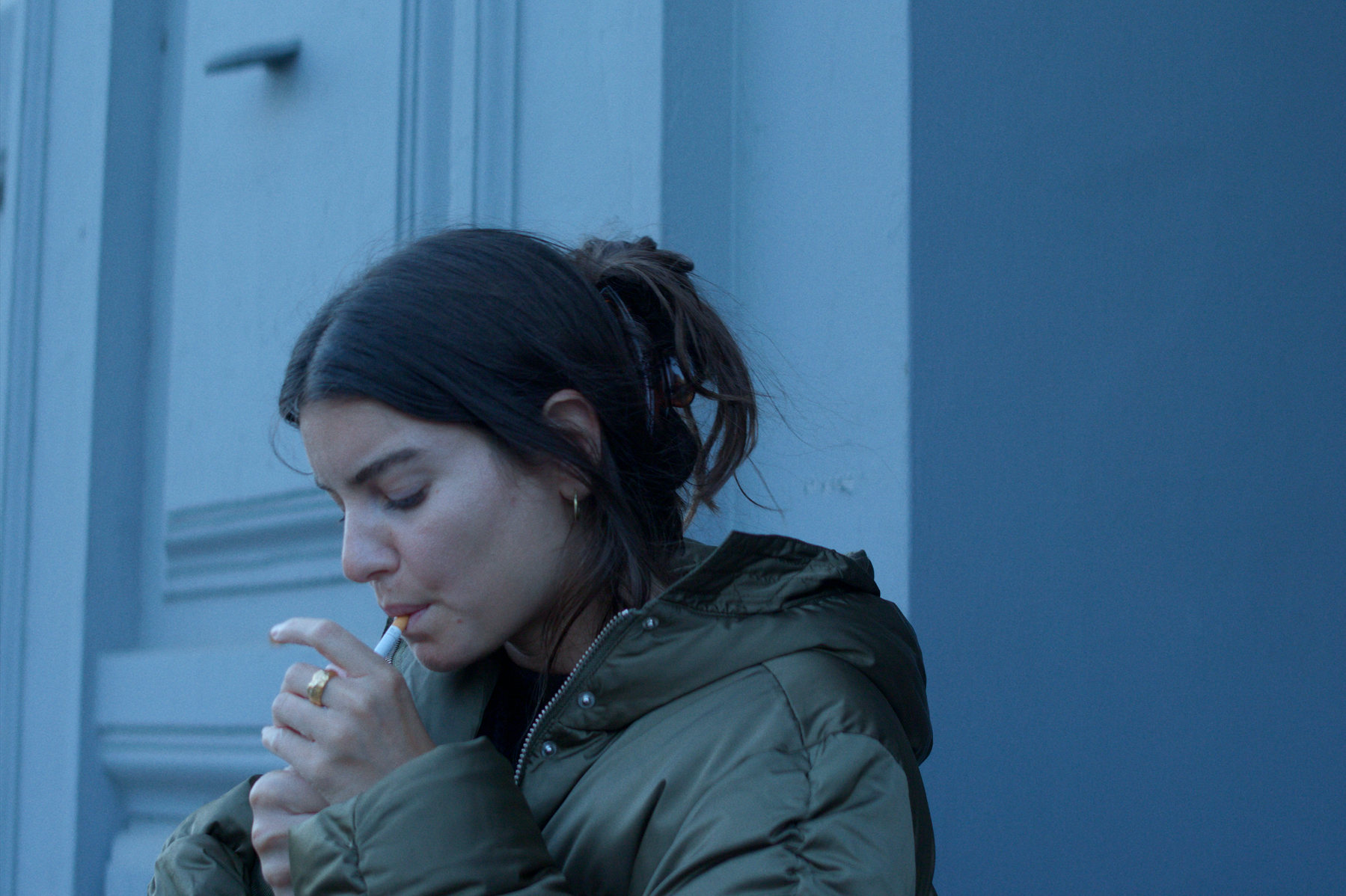 Karen lighting a cigarette outside in Hysterisk