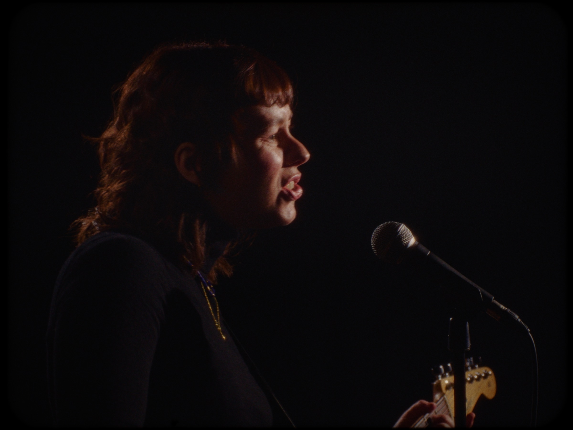 Julie Ellinor performing with guitar and microphone