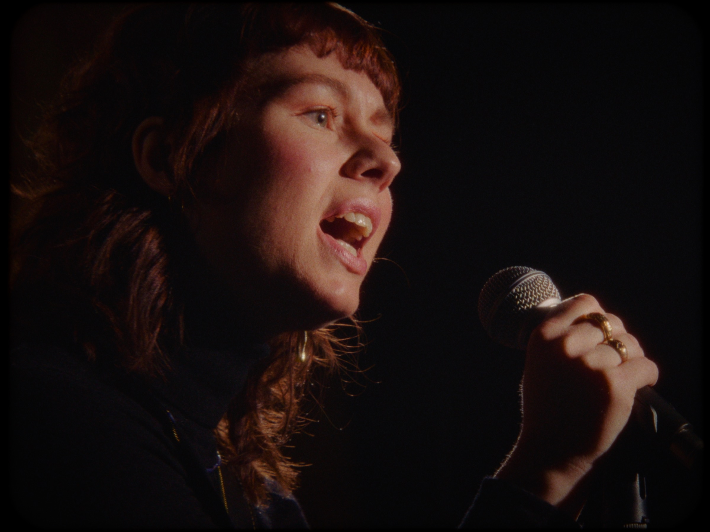 Julie Ellinor singing into a handheld microphone